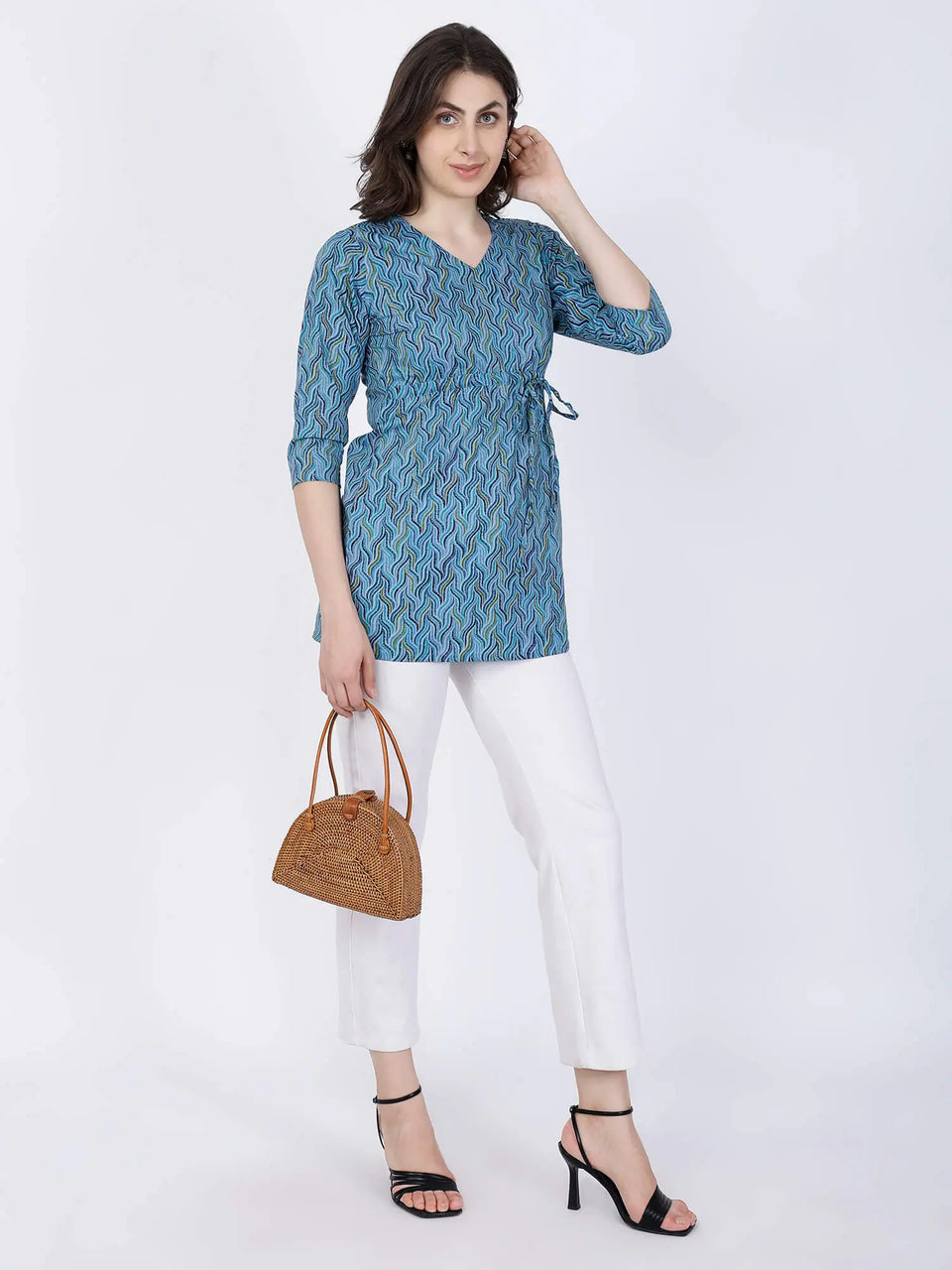 Woman wearing Blue Printed Short Kurti styled with white pants