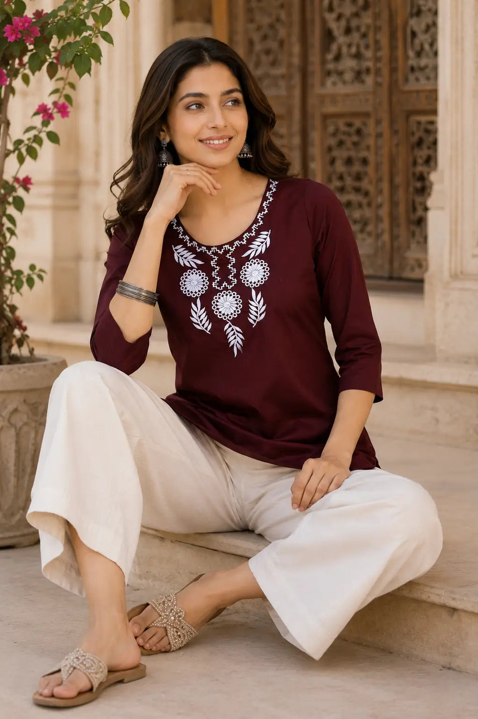 Rabric maroon cotton embroidered short top for women in elegant sitting pose with casual ethnic accessories