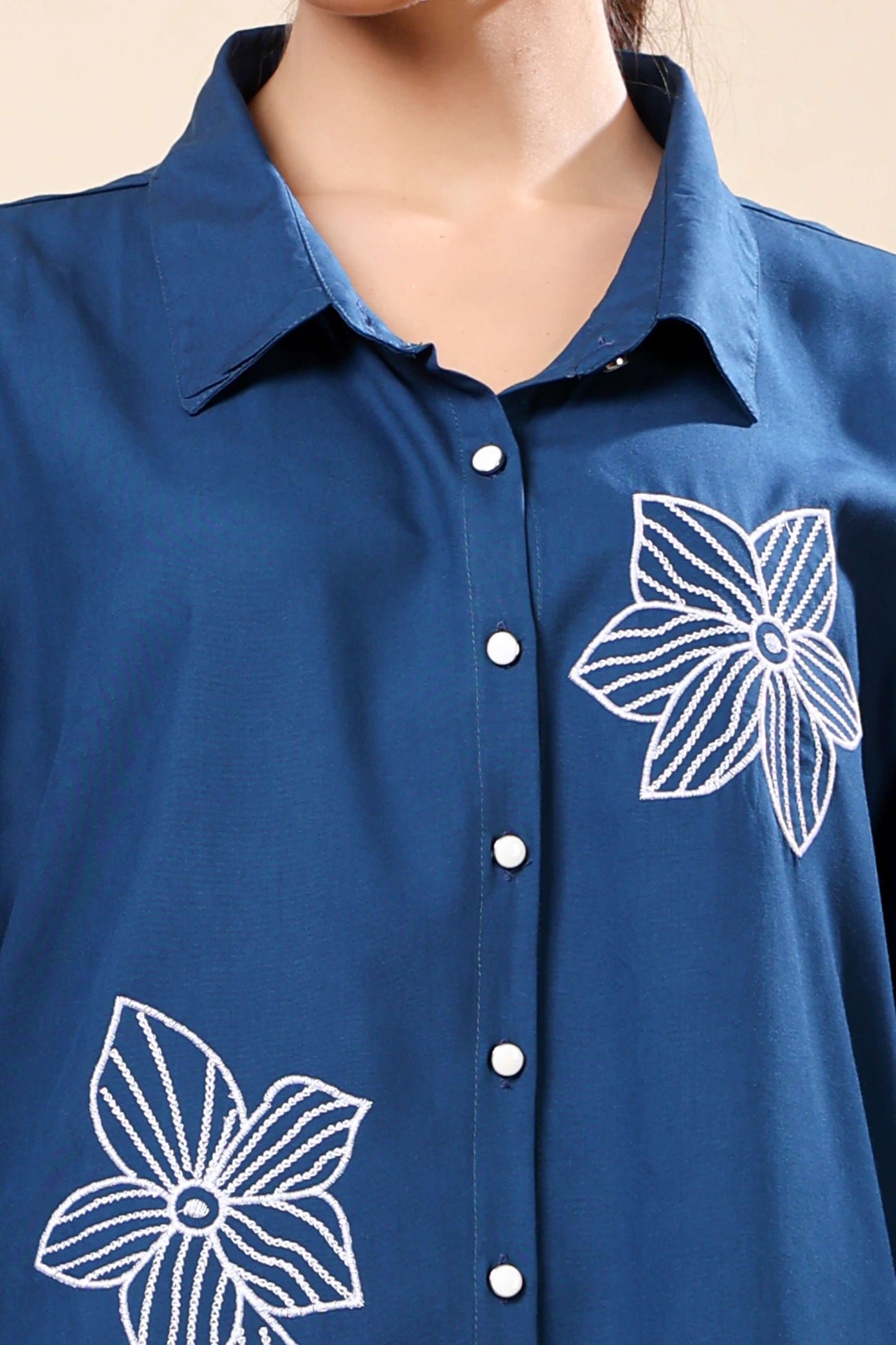 Close-up of white floral embroidery on Rabric navy blue co-ord set