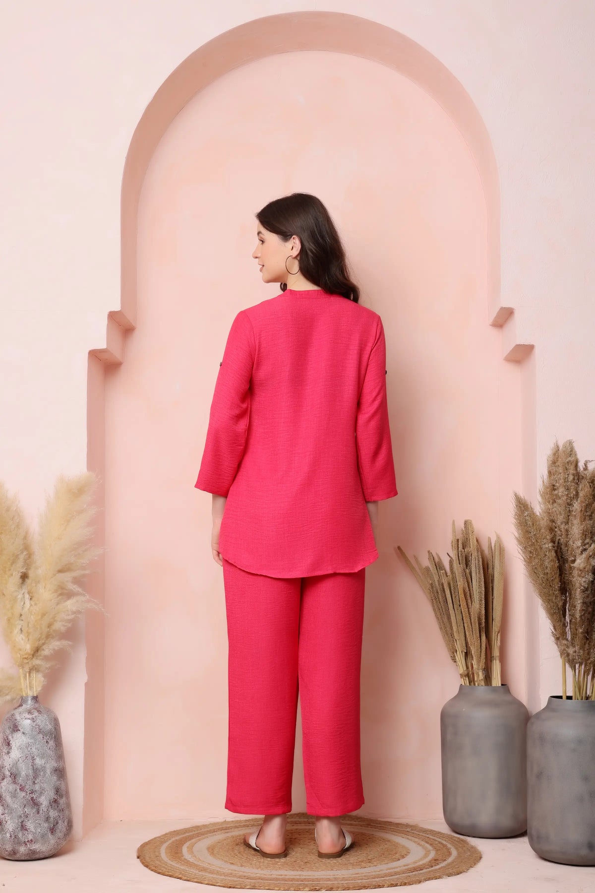 Back view of RABRIC coral pink twill co-ord set showing the curved top hem and relaxed trouser fit