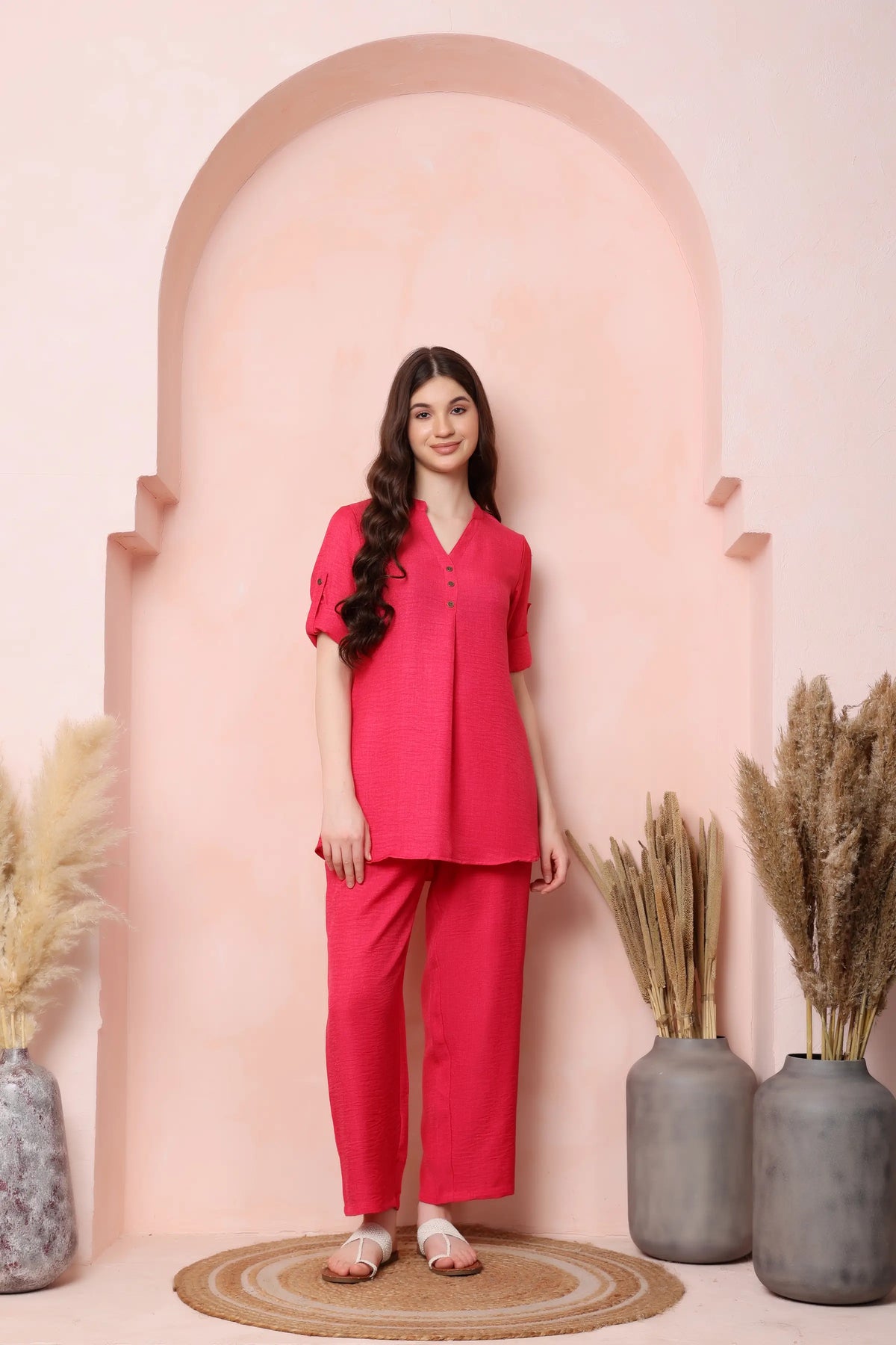 Model in an angled standing pose wearing RABRIC coral pink twill co-ord set