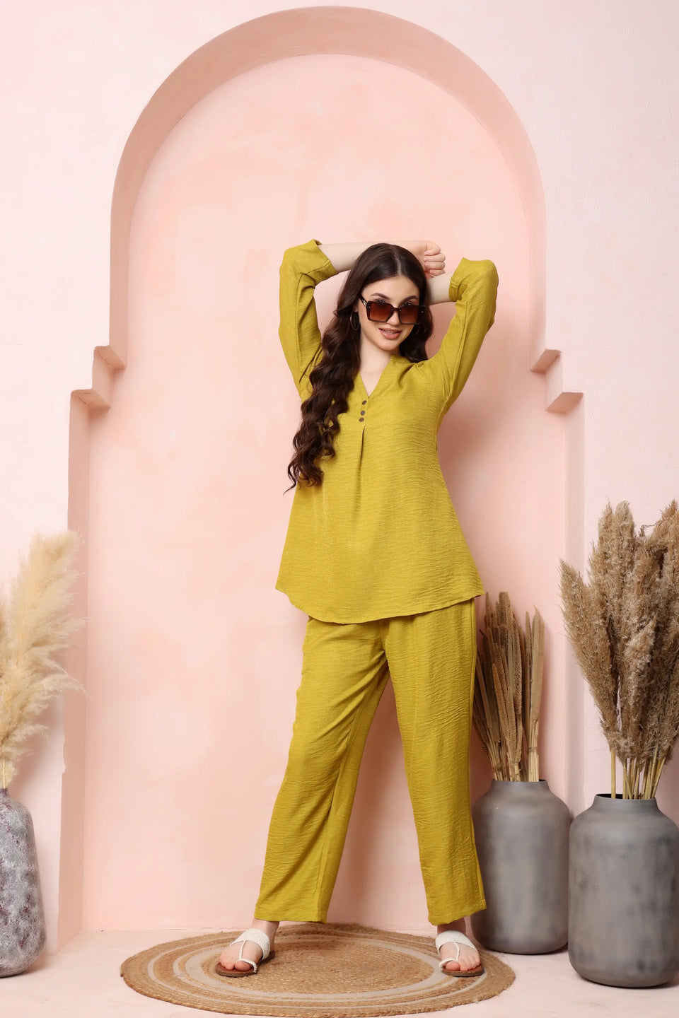 Model standing at an angle in RABRIC mustard yellow twill co-ord set with a flared top and matching trousers.