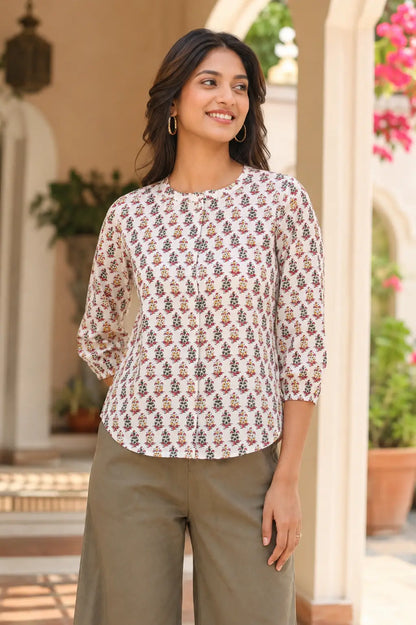 Lifestyle image of woman wearing Rabric white floral cotton short top styled with casual wide leg pants and accessories