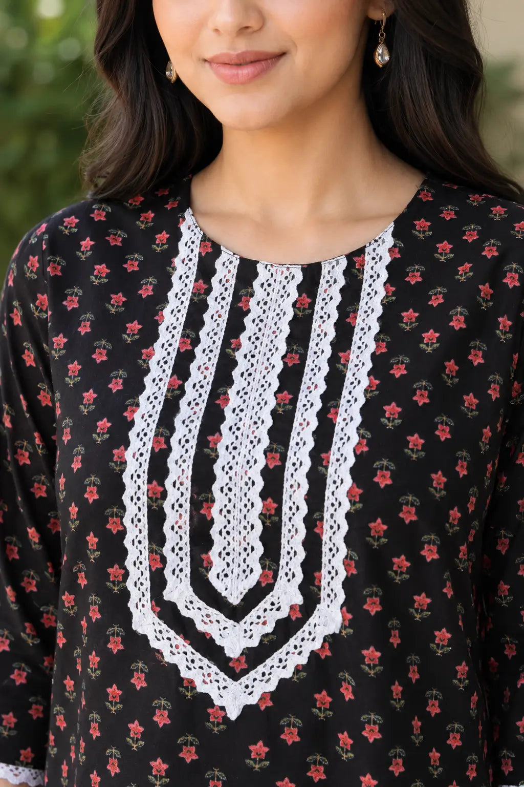 Close-up of Rabric black cotton floral kurti with detailed white embroidered lace V-neck design and red floral print