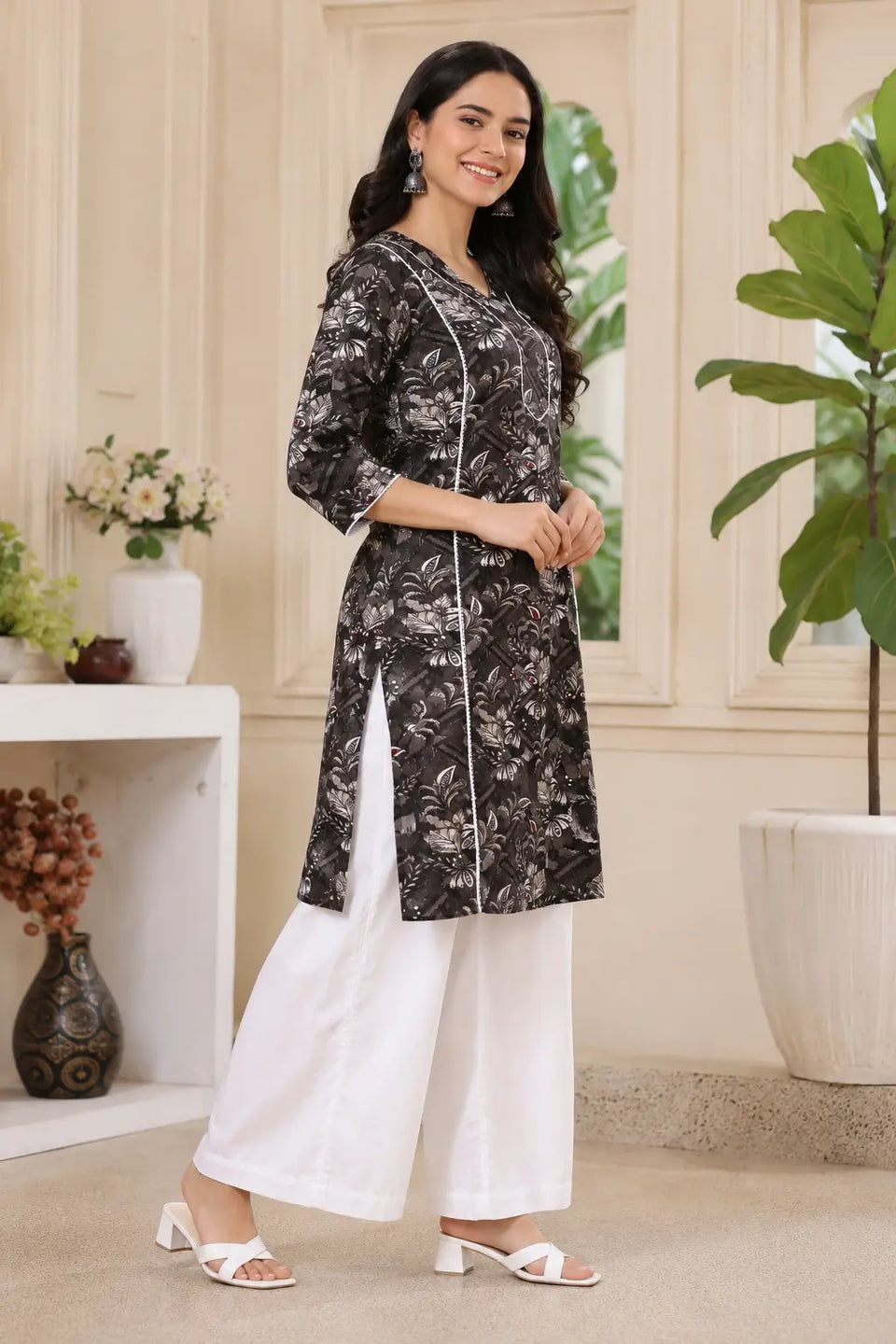 Side angle view of Rabric black floral cotton kurti for women with comfortable fit and white palazzo styling