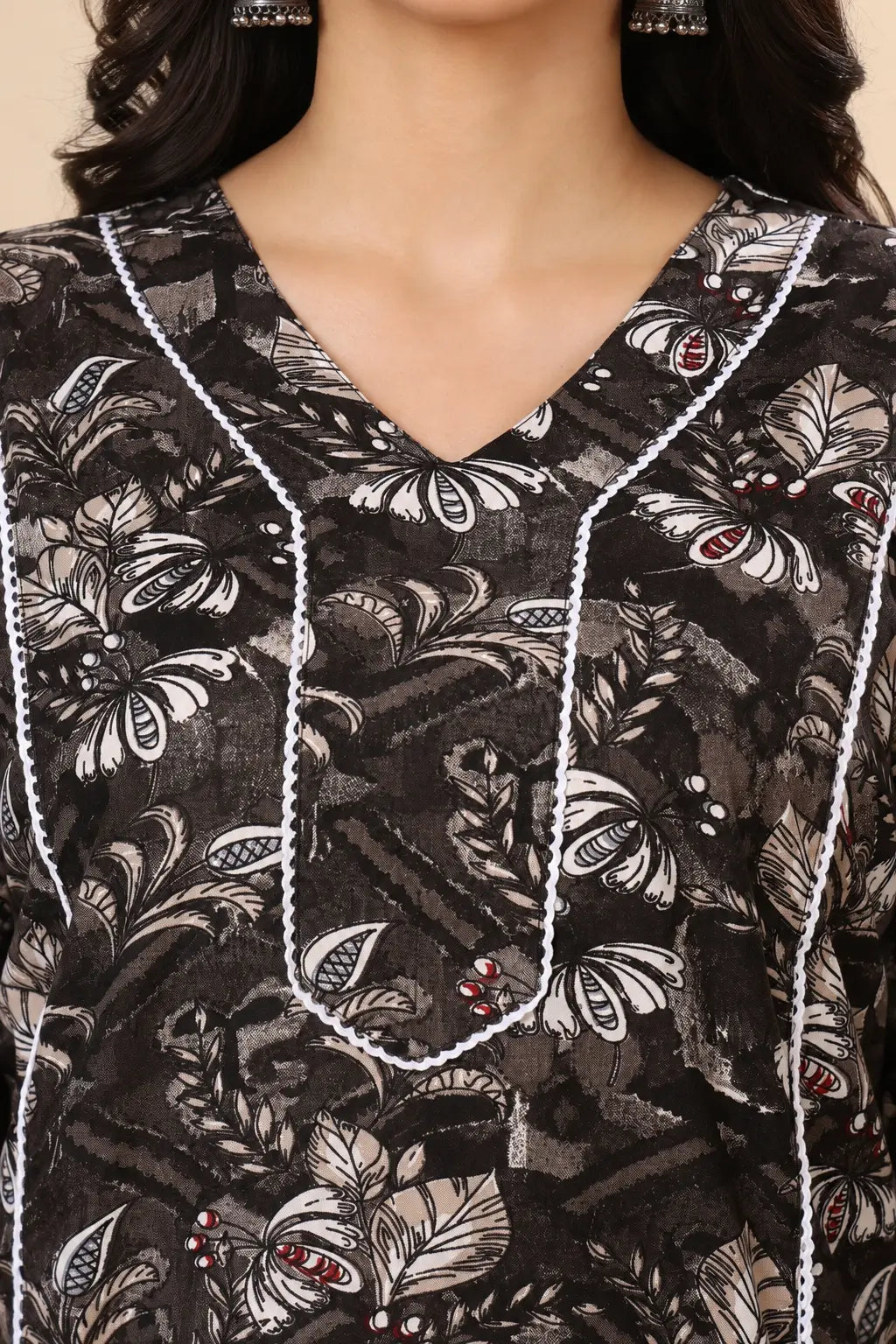 Close up of stylish V neck design on Rabric black floral cotton kurti for women with detailed piping work