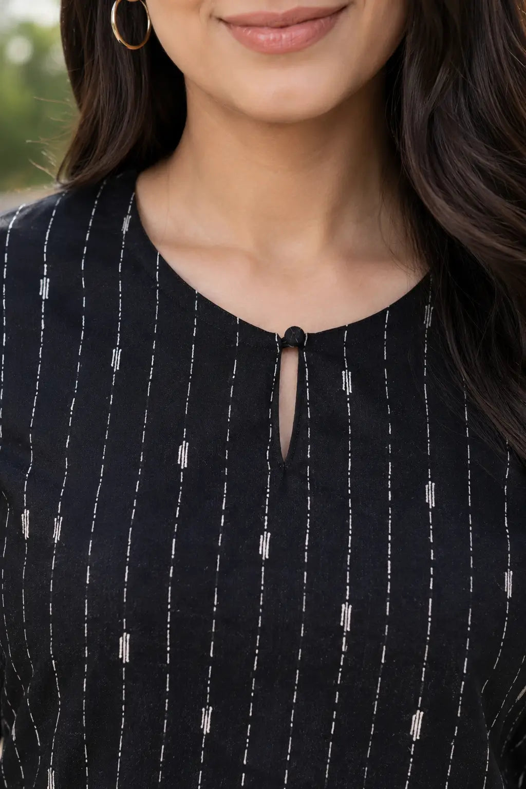 Neck detail of Rabric black cotton co-ord set for women showing round keyhole neckline and white vertical dashed stripe print