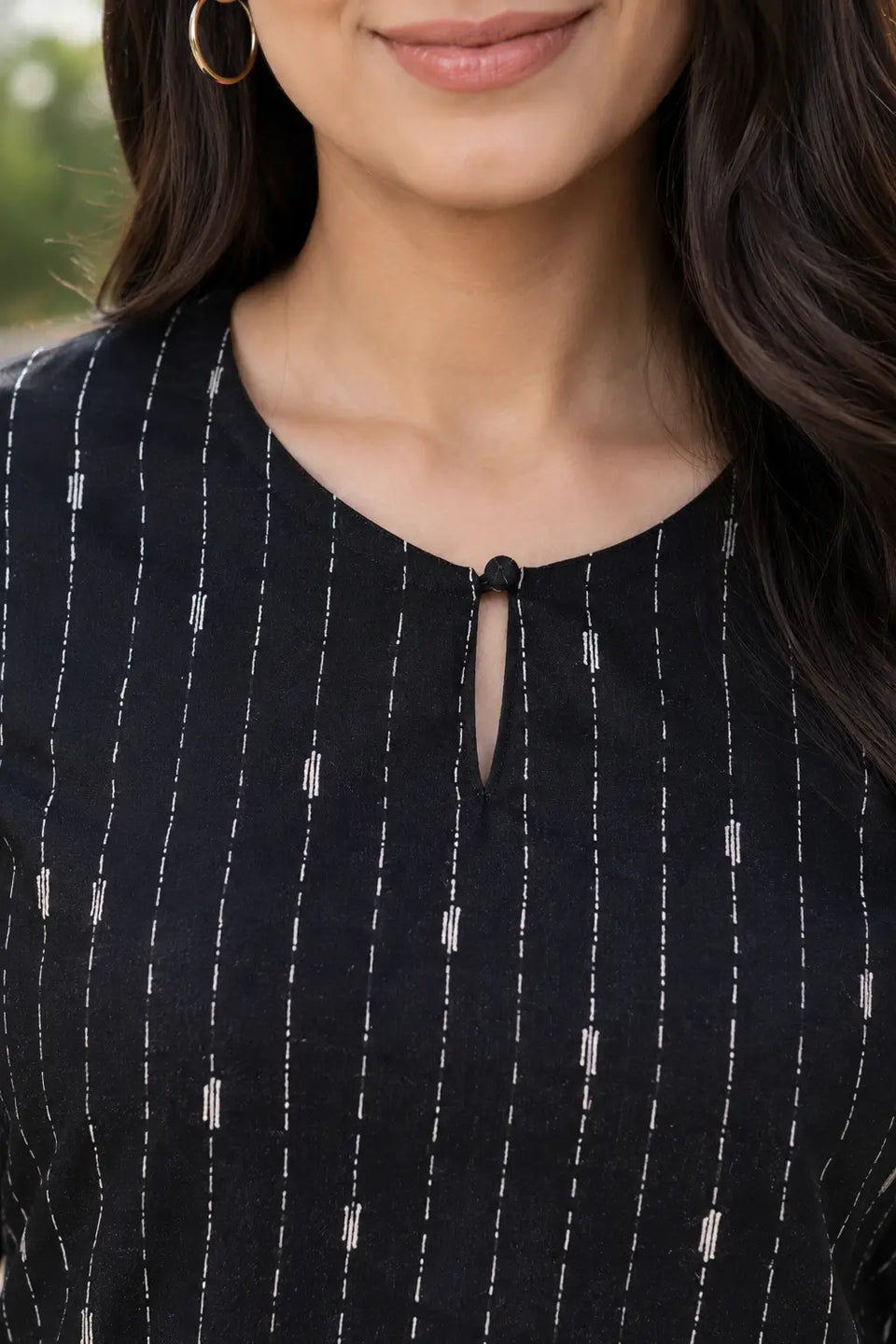 Neck detail of Rabric black cotton co-ord set for women showing round keyhole neckline and white vertical dashed stripe print