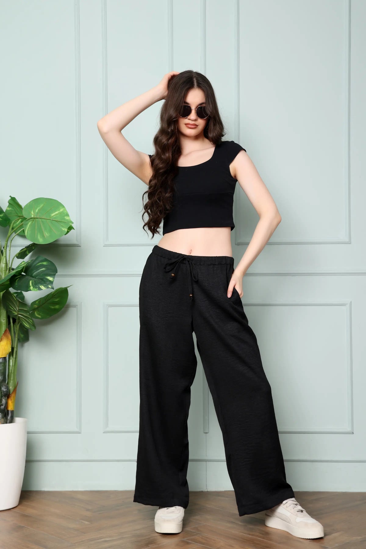 RABRIC black linen trousers for women standing pose showing broad fit, wide legs and two pockets