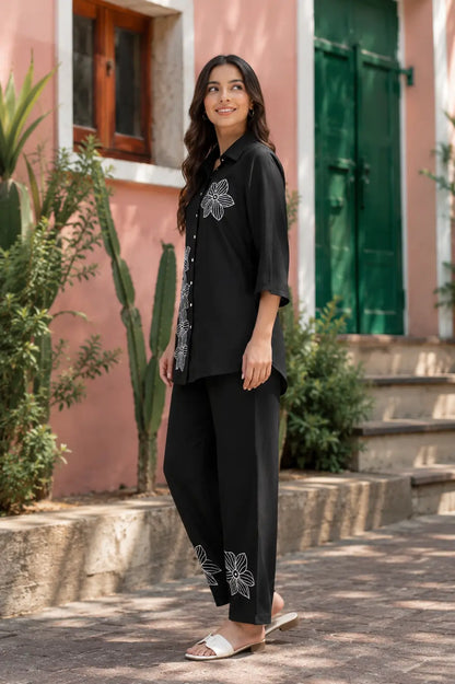 Rabric black rayon co-ord set side angle showing white floral embroidery on shirt and pants with relaxed stylish fit