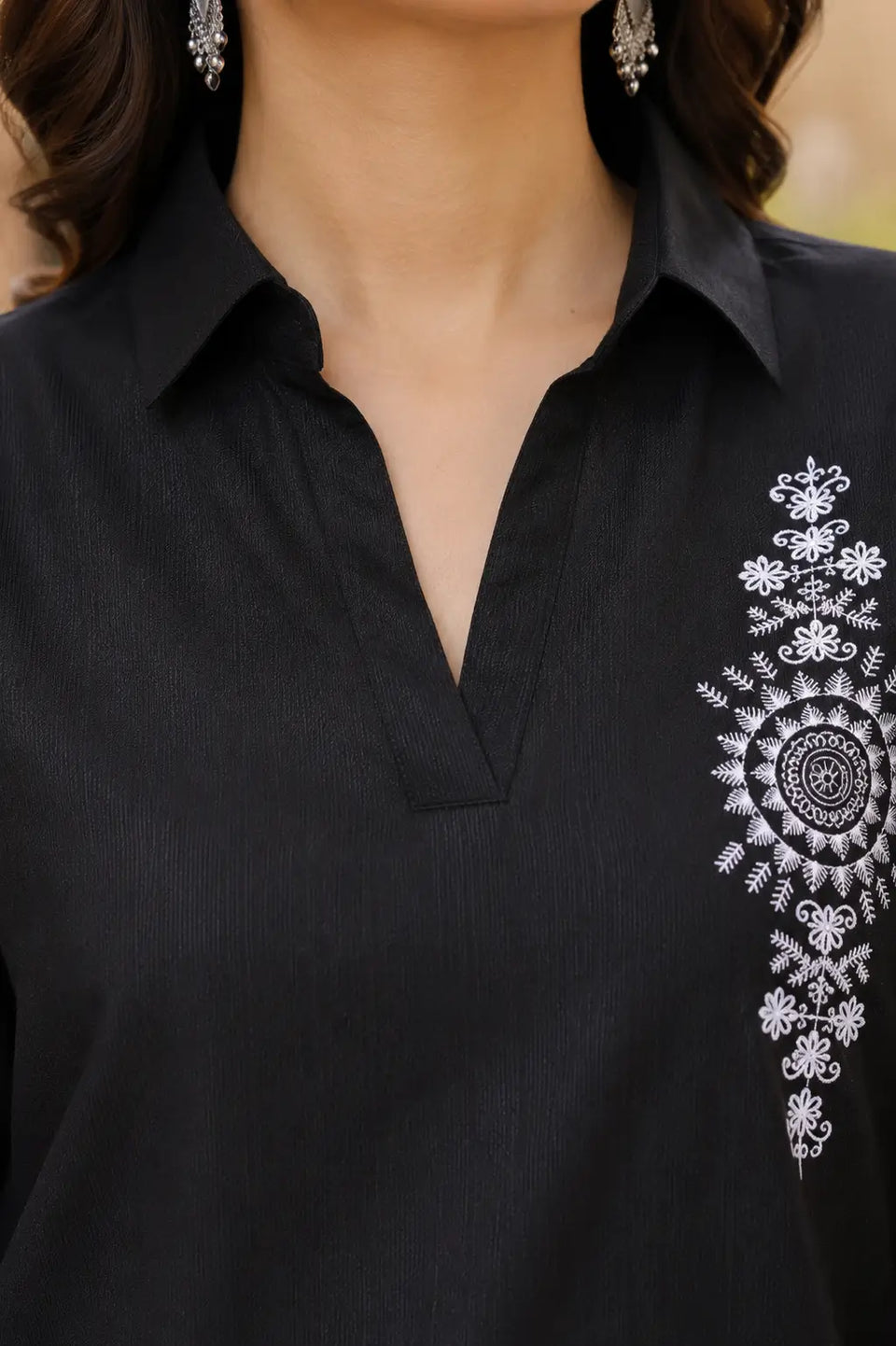Close-up of Rabric black vertican silk co-ord set showcasing designer collar neck with white floral mandala embroidery detailing.