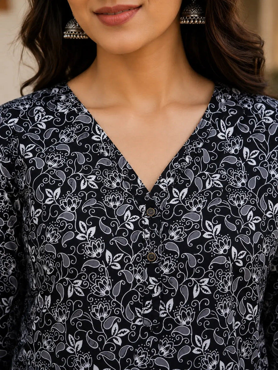 Close up neck design of Rabric black and white floral cotton V neck short top for women with elegant button detailing