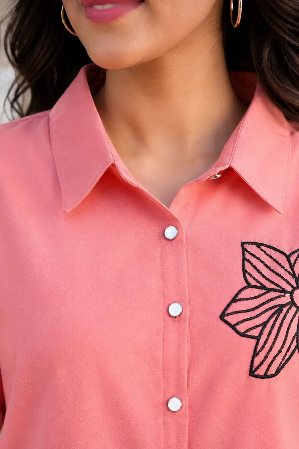 Close-up neck design of Rabric coral pink rayon co-ord shirt with collar, front buttons and black floral print embroidery detail