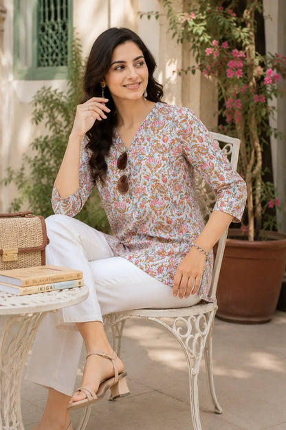 Women wearing Rabric floral cotton short top in relaxed sitting pose with stylish accessories and white pants