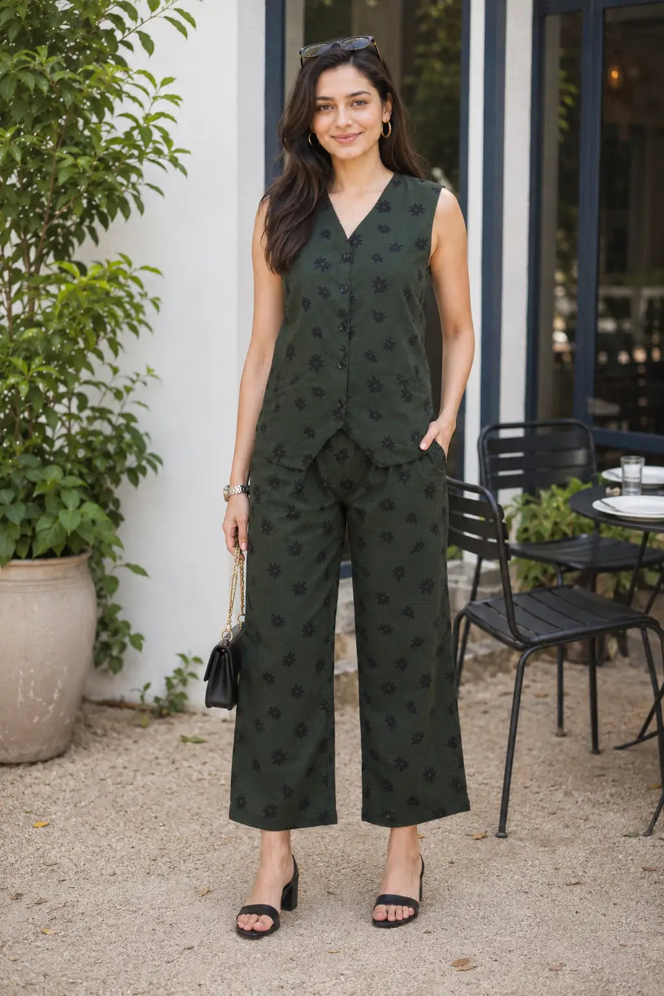 Rabric dark olive green cotton floral printed casual co-ord set for women styled outdoors with sleeveless V-neck top and wide leg pants