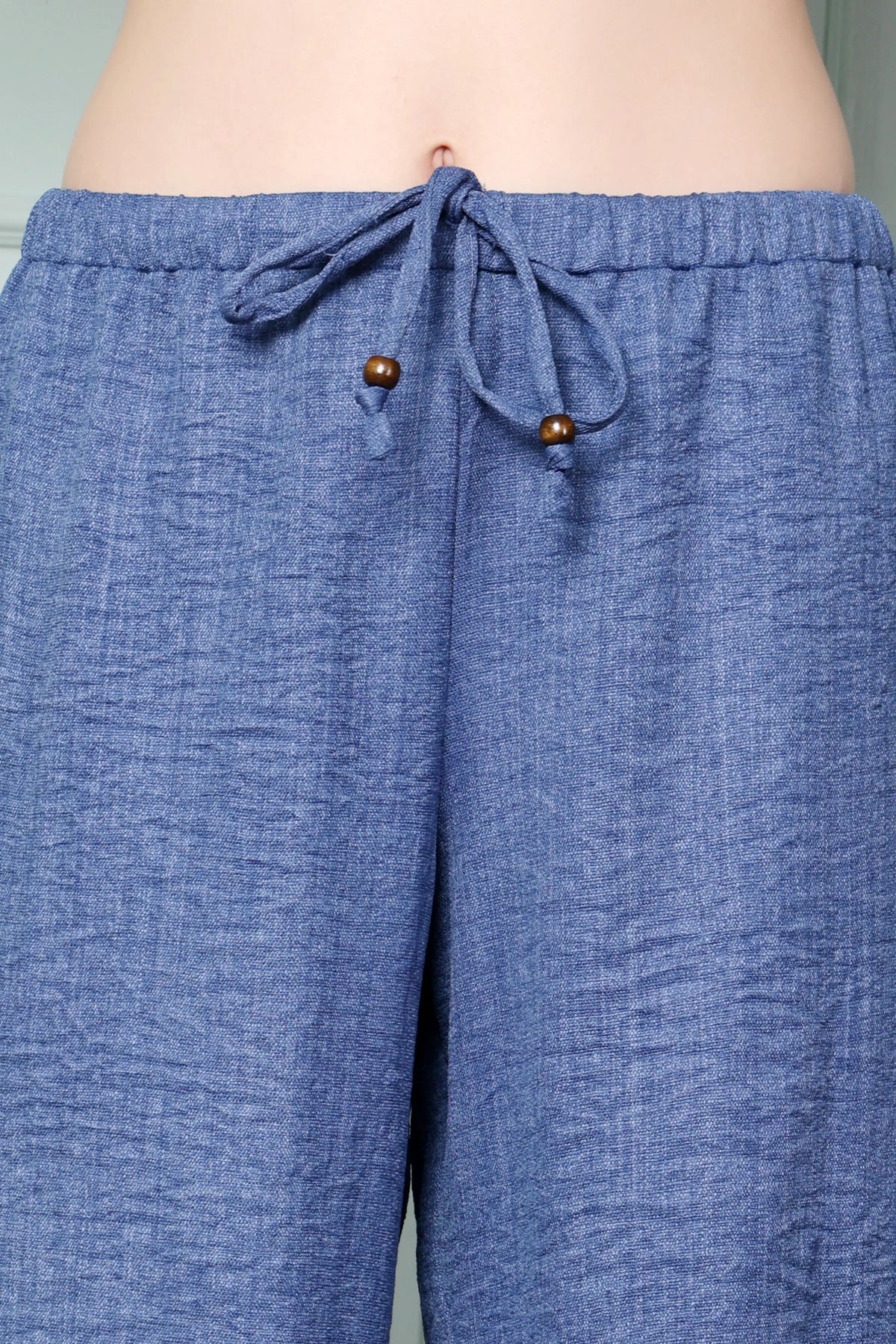 RABRIC Denim Blue linen trousers close-up showing drawstring with wooden bead detailing