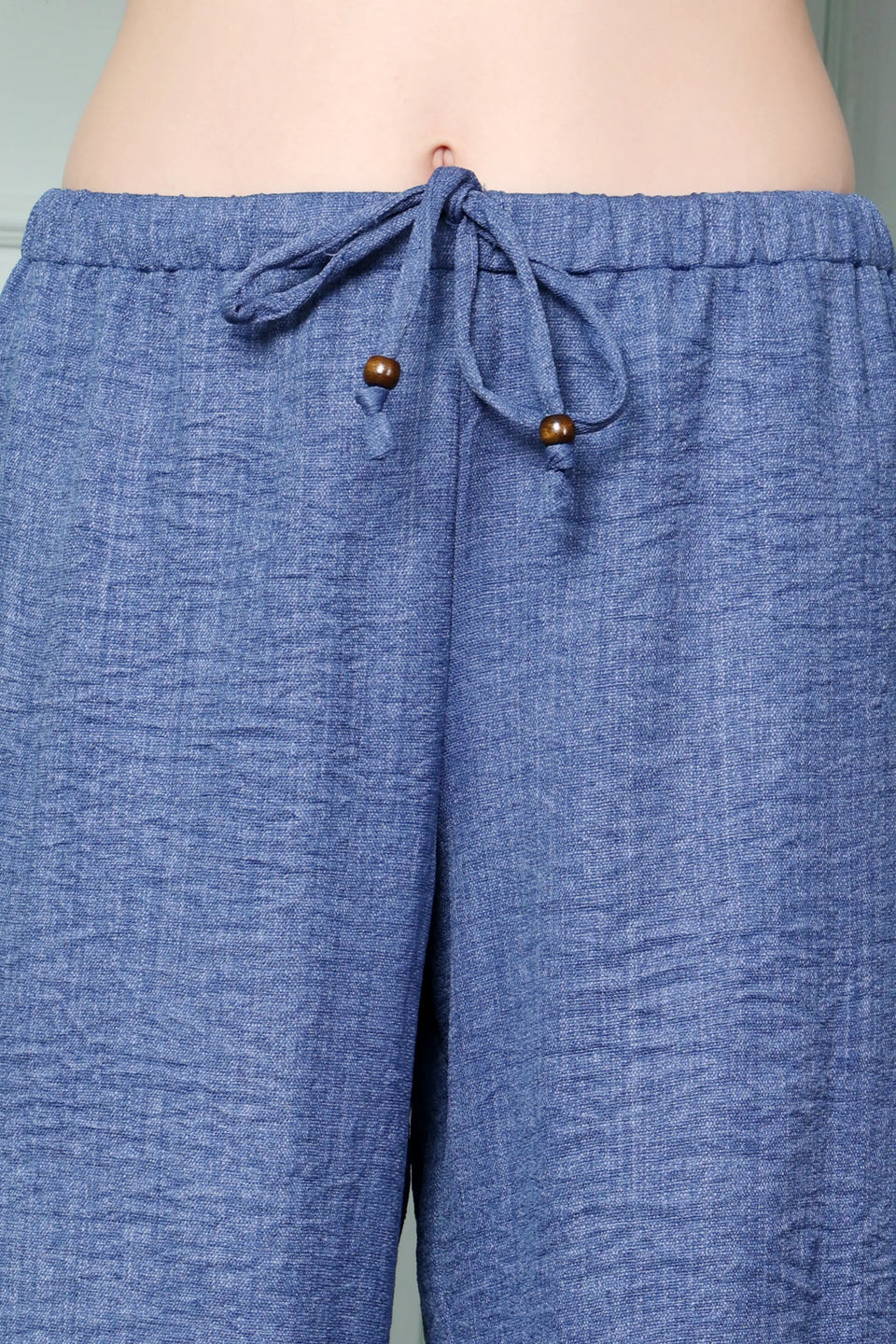 RABRIC Denim Blue linen trousers close-up showing drawstring with wooden bead detailing