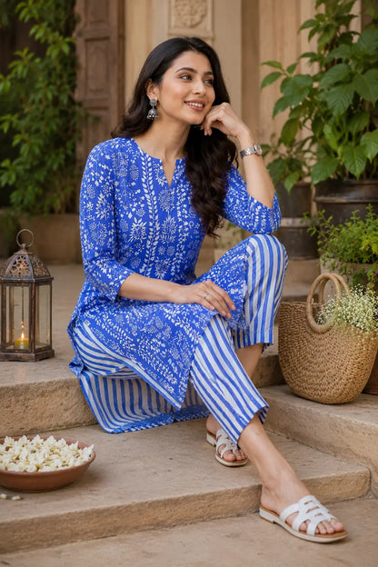 Rabric floral blue cotton kurta pant set for women shown in elegant casual sitting pose with handcrafted accessories