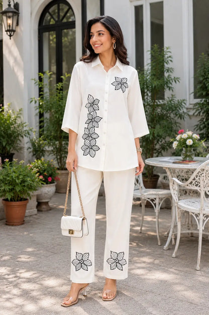 Full product lifestyle image of Rabric ivory rayon co-ord set for women with embroidered shirt, matching pants and casual handbag accessories