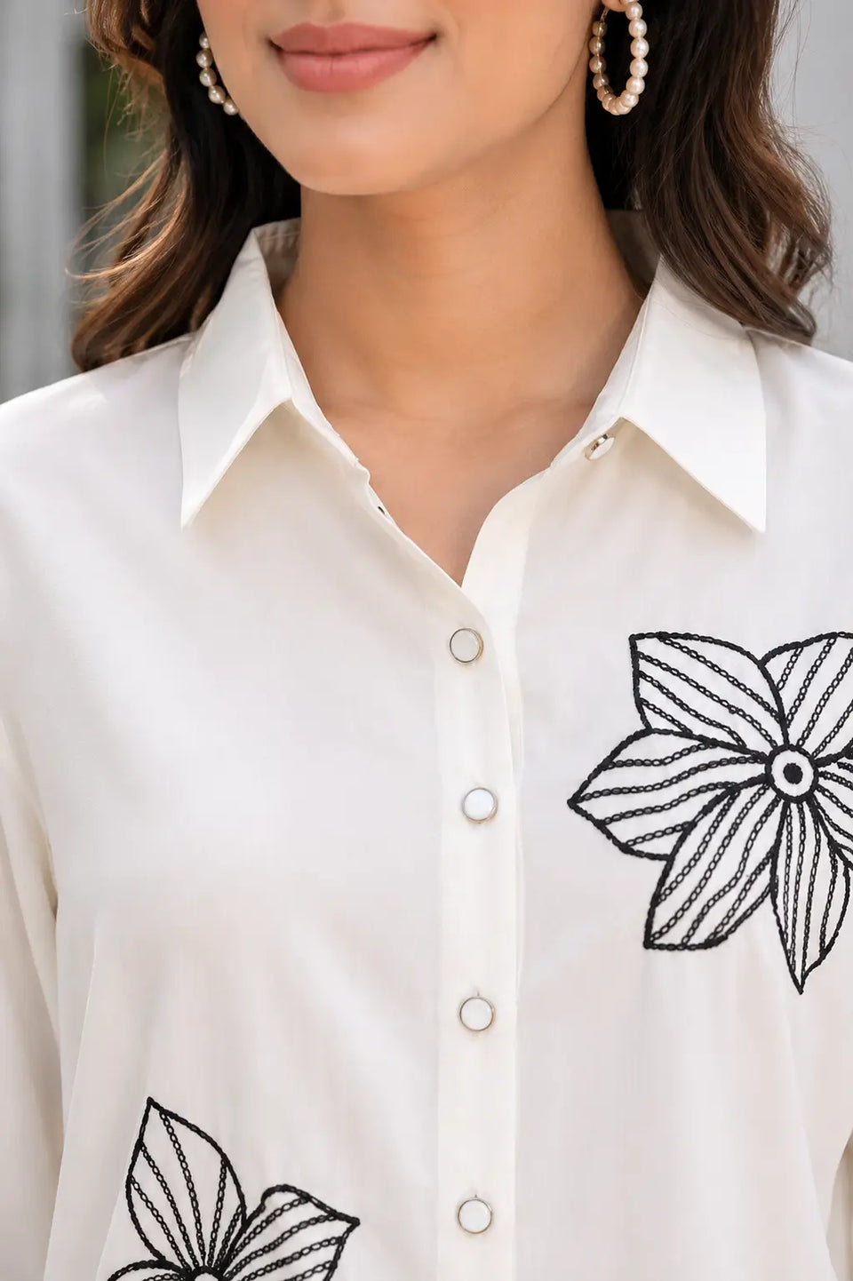 Close-up neck design of Rabric ivory rayon co-ord set showing shirt collar, button front and black floral embroidered detail