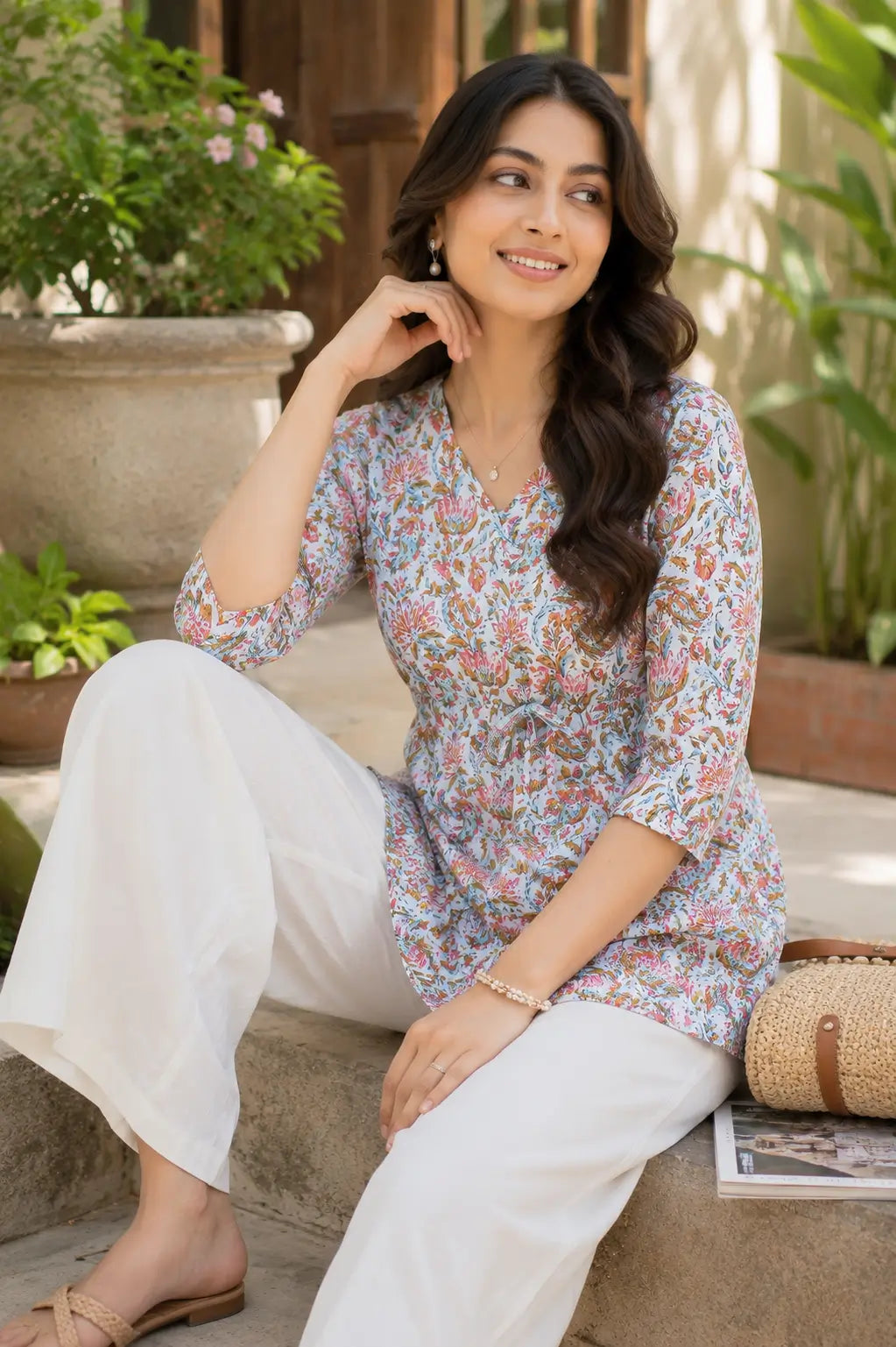 Rabric light blue floral cambric cotton short top for women in stylish sitting pose with modern casual accessories and summer fashion styling