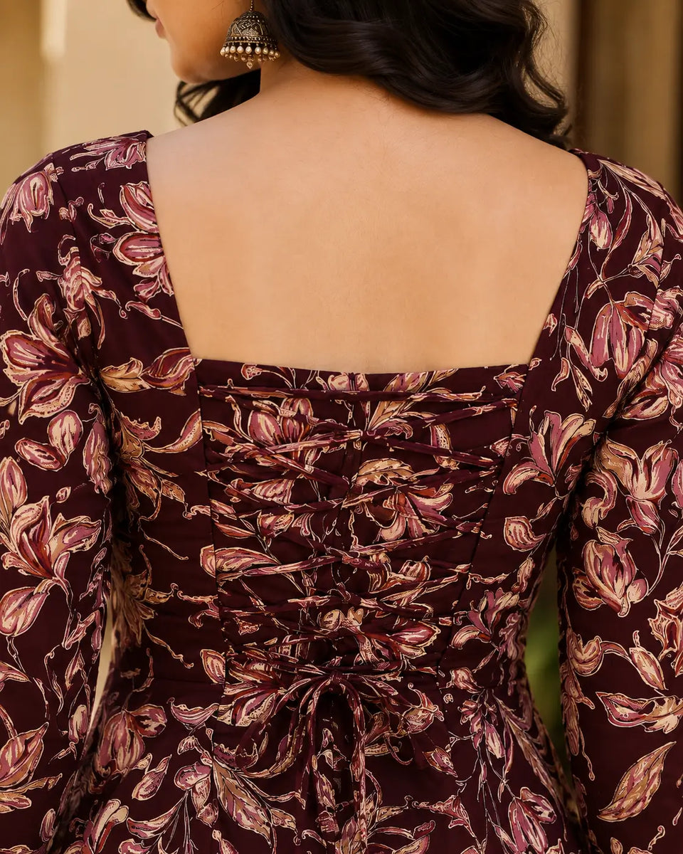 Closeup of Rabric maroon floral print cotton short top featuring adjustable back dori lace-up detailing and botanical floral print.