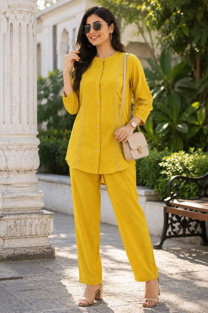 Woman wearing Rabric mustard yellow Vertican Silk co-ord set styled for summer outings with elegant accessories and comfortable straight pants.