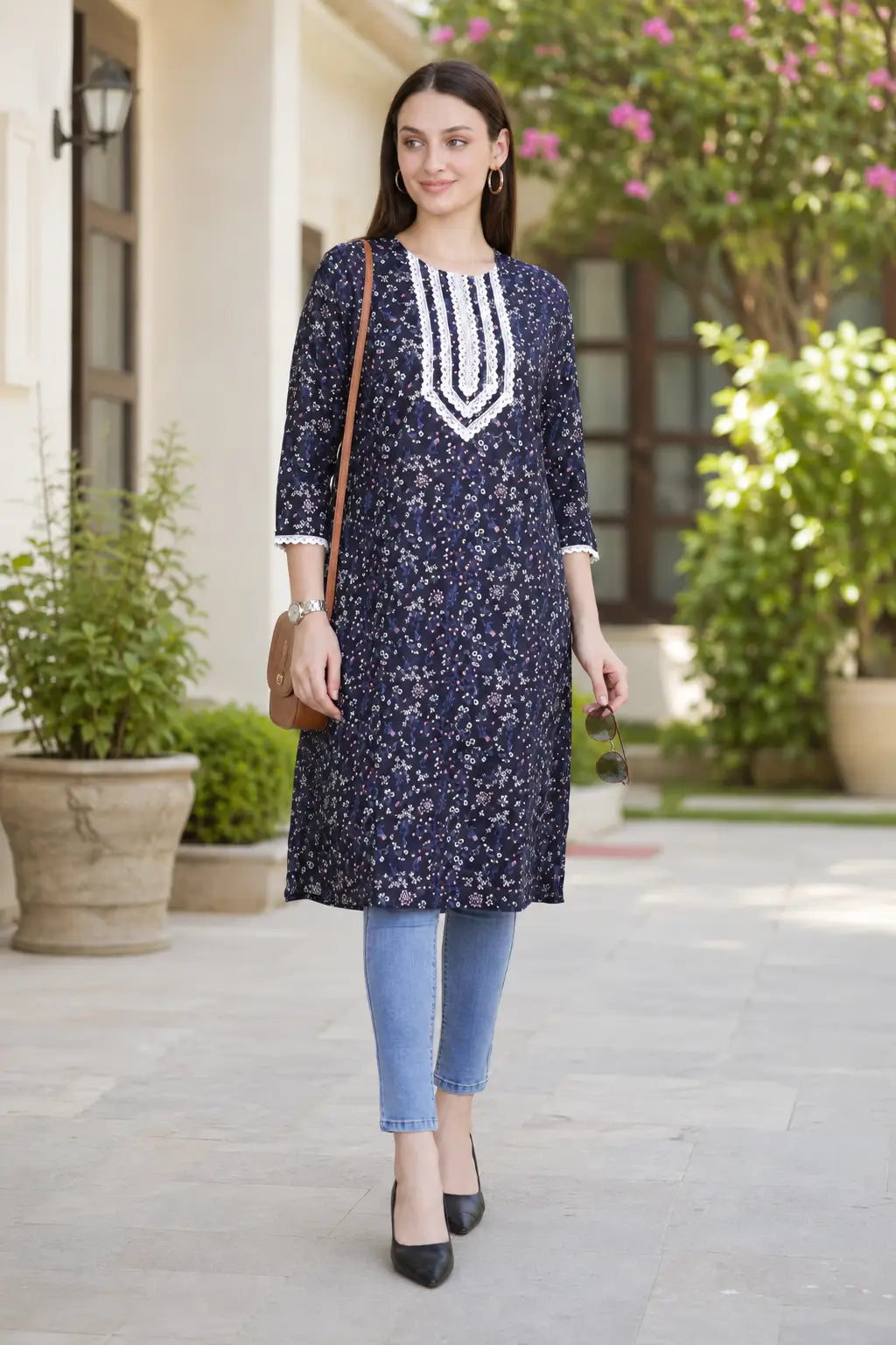 long-kurti-casual-wear-women.webp
Rabric navy blue cotton floral printed long kurti for women styled with jeans and sling bag, featuring V-neck white embroidery for casual wear.
