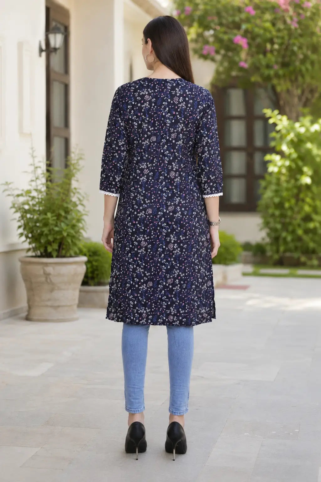 Back view of Rabric navy blue cotton long kurti for women with all-over multicolor small floral print, straight fit and 3/4 sleeves.