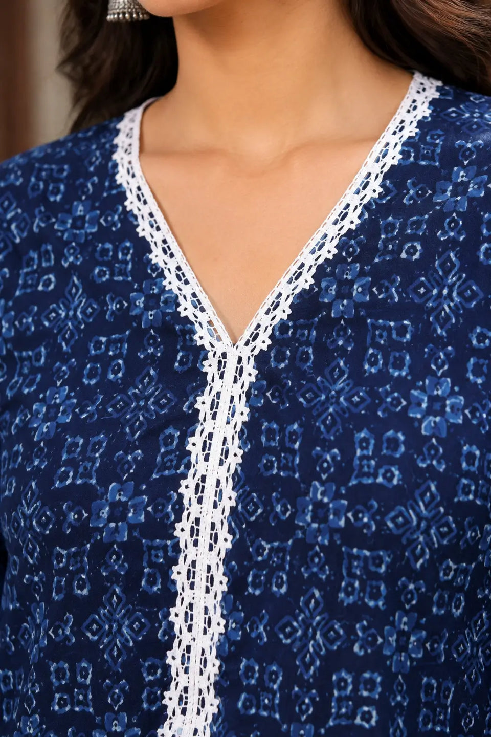 Close-up of Rabric navy blue cotton printed kurti V neck featuring white embroidered lace neckline and light blue geometric floral print