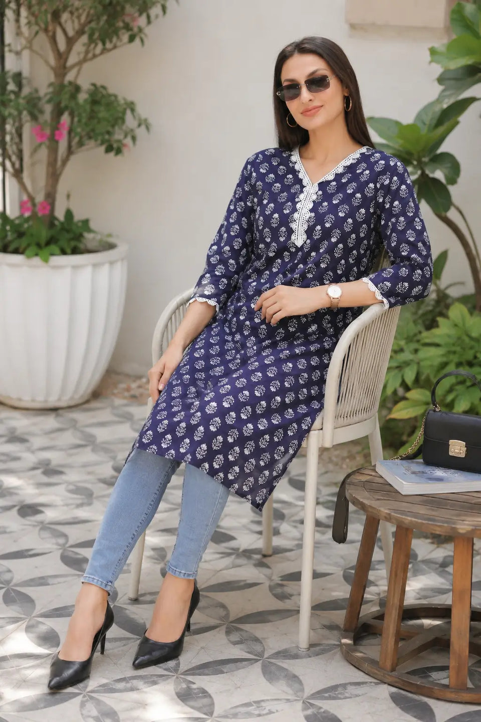 Rabric navy blue cotton straight kurti for women with white leaf floral print and embroidered V-neck styled with jeans for a casual café look