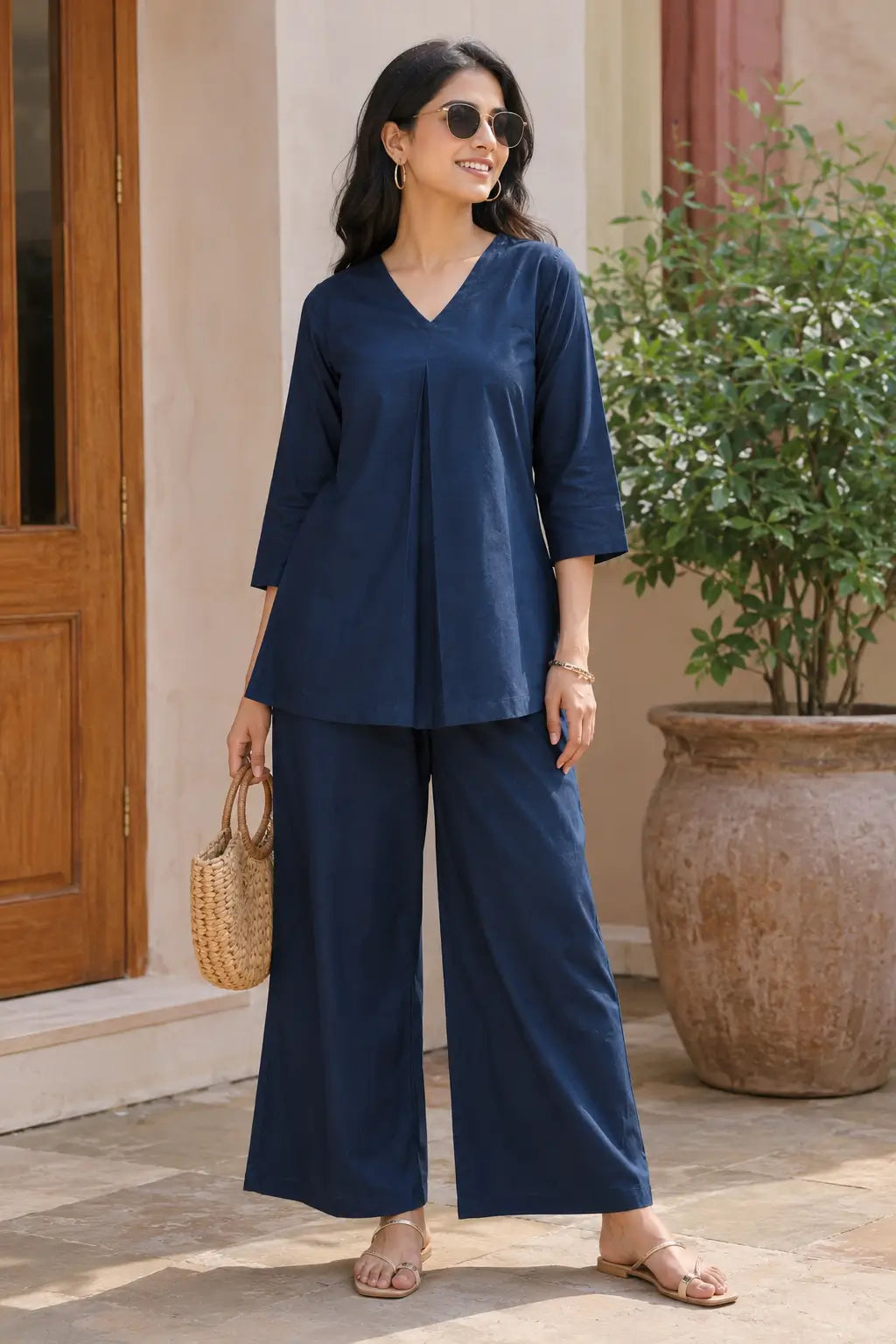 Lifestyle image of Rabric navy blue solid cotton co-ord set for women styled with casual accessories