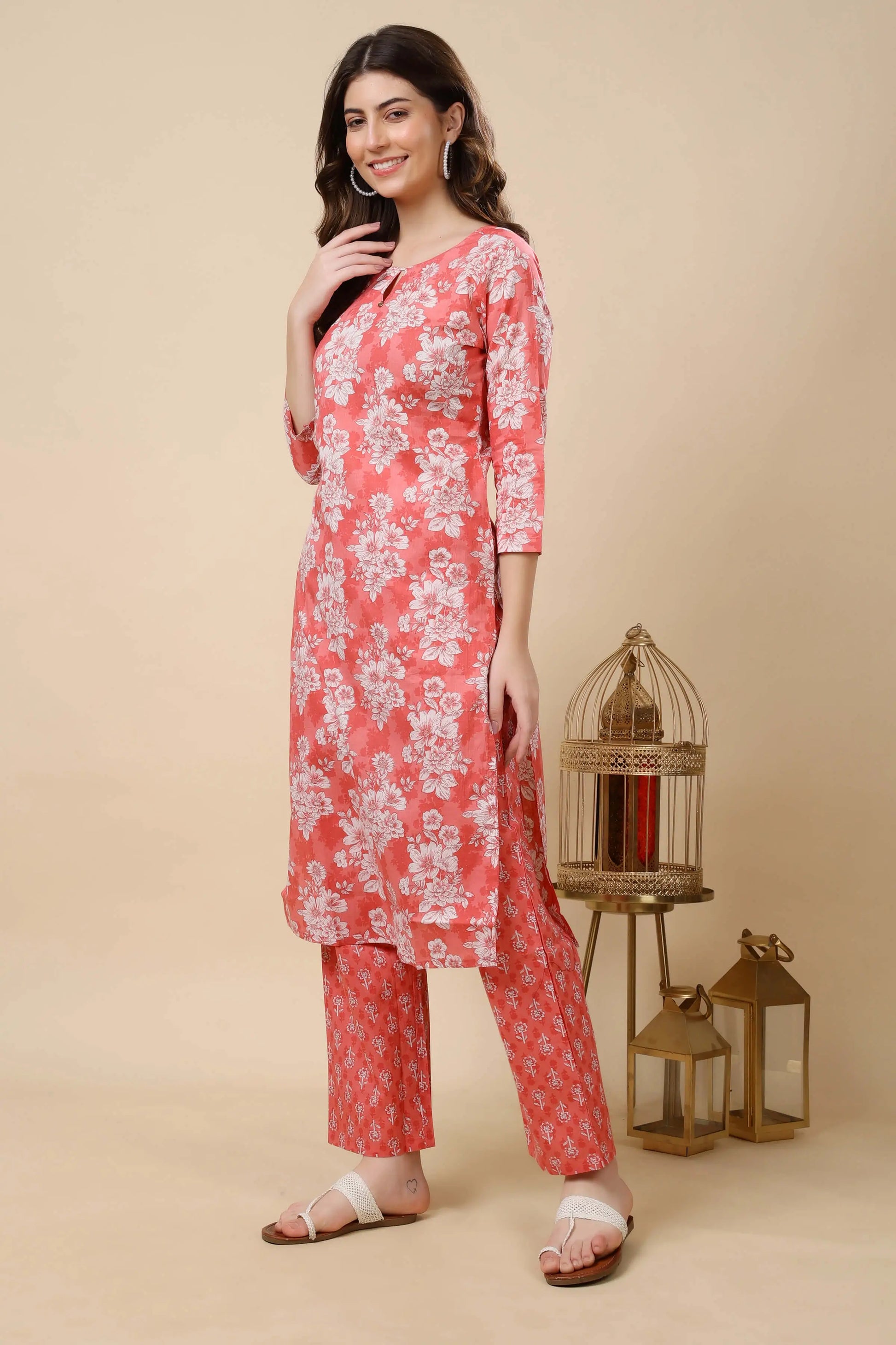 Side pose of woman wearing floral printed coral pink kurti set by Rabric