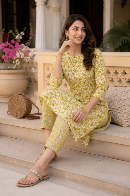 Rabric mustard yellow rayon kurta pant set for women in casual sitting pose with stylish ethnic accessories