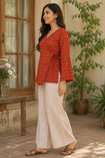 Side view of Rabric rust red cotton floral print short top with wrap style and full bell sleeves