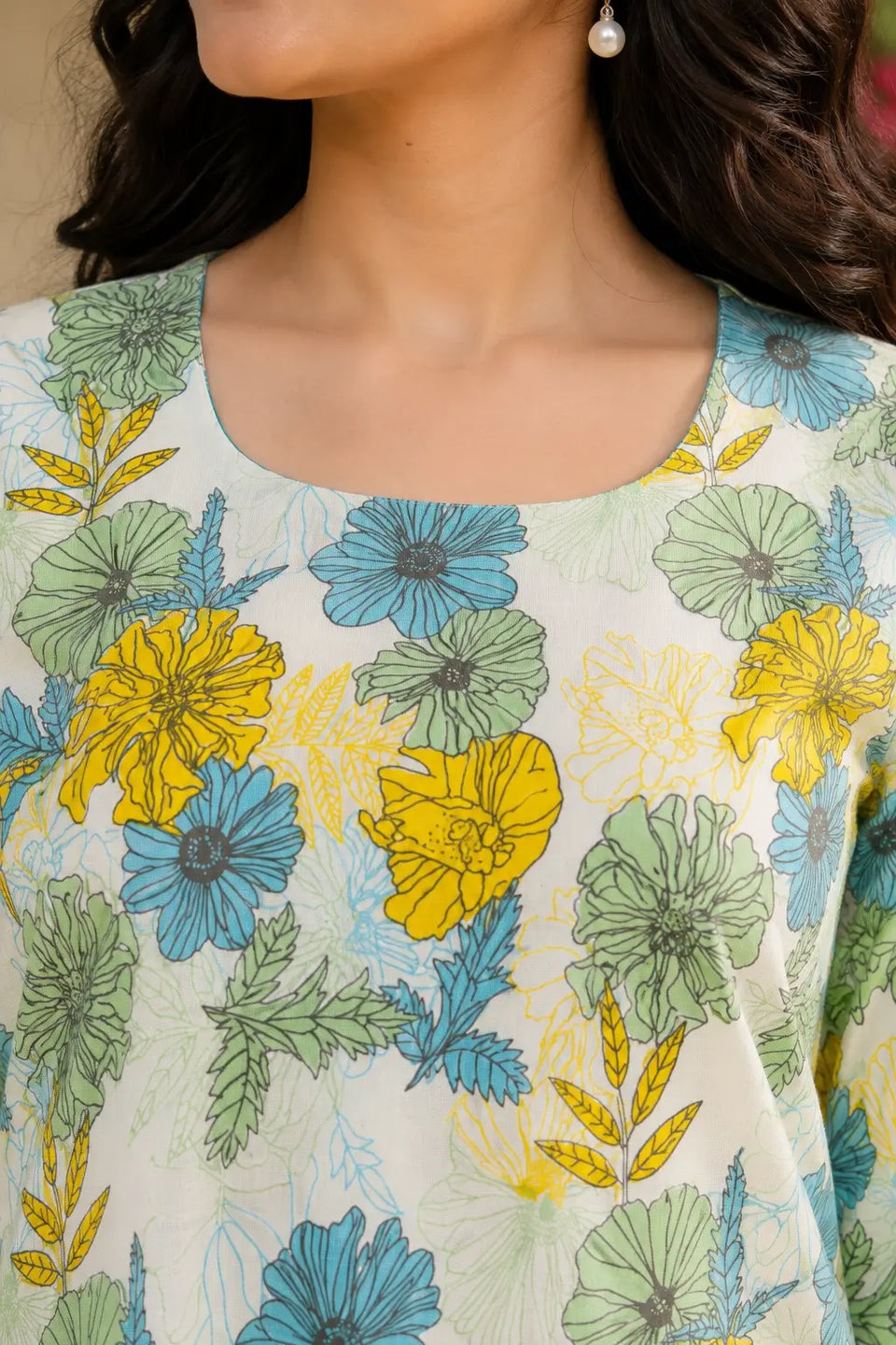 Close-up of RABRIC floral tunic top showing round neckline and pastel flower print details