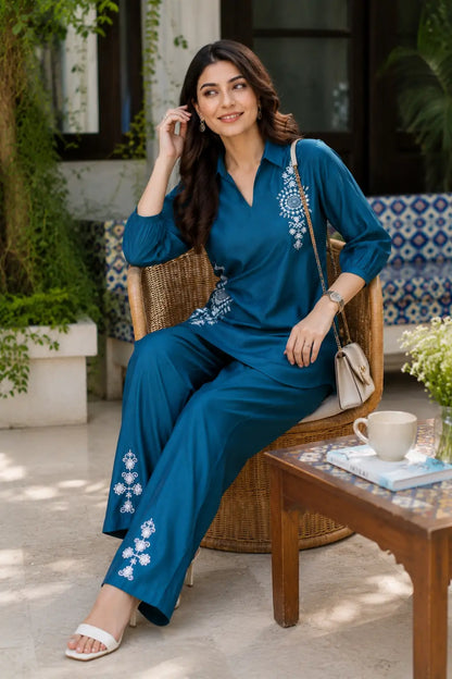 Rabric teal blue Vertican silk embroidered co-ord set showcased in a relaxed sitting pose highlighting elegant embroidery, premium fabric and contemporary styling.