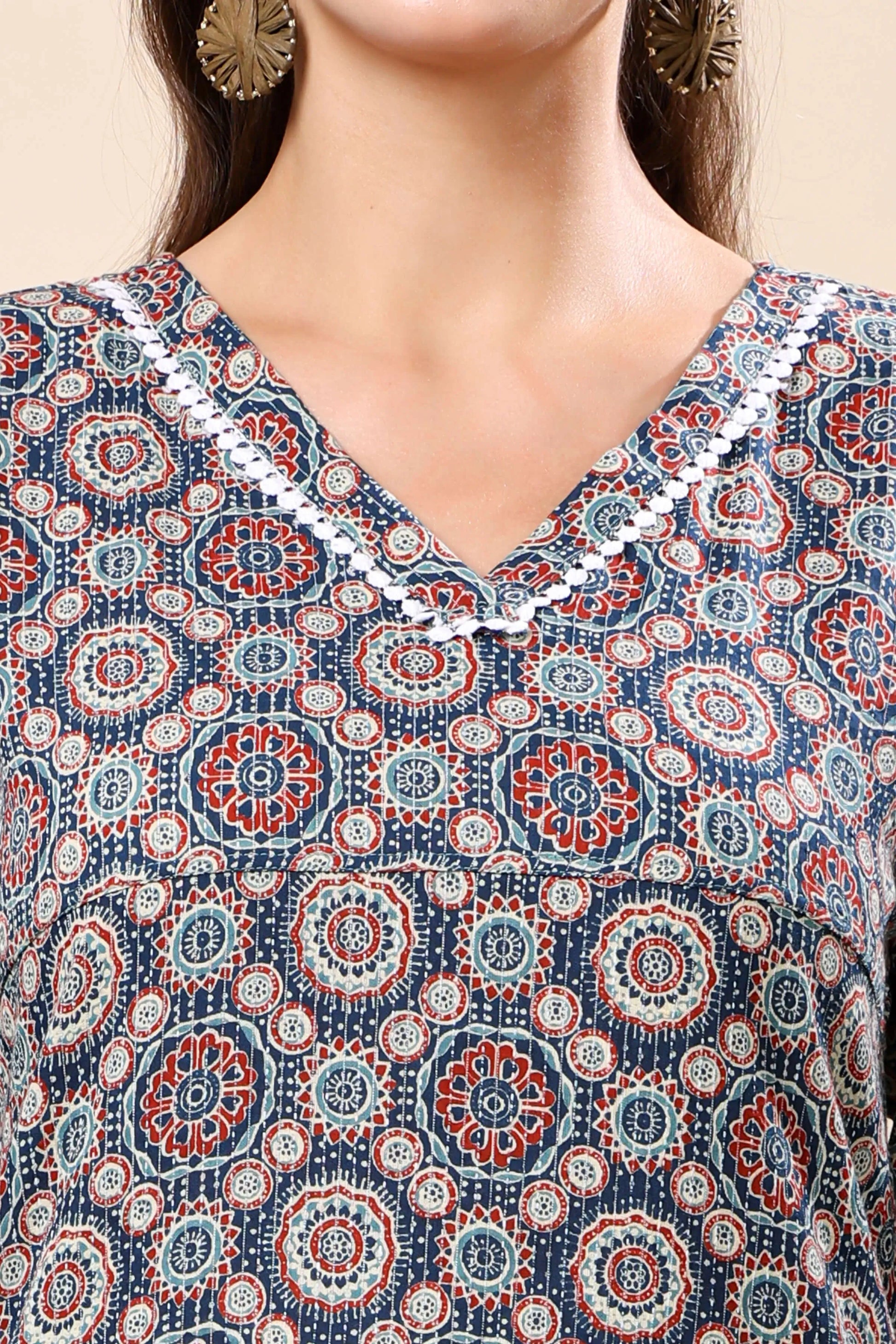 Close-up of geometric mandala print and lace detailing on V-neck kurti