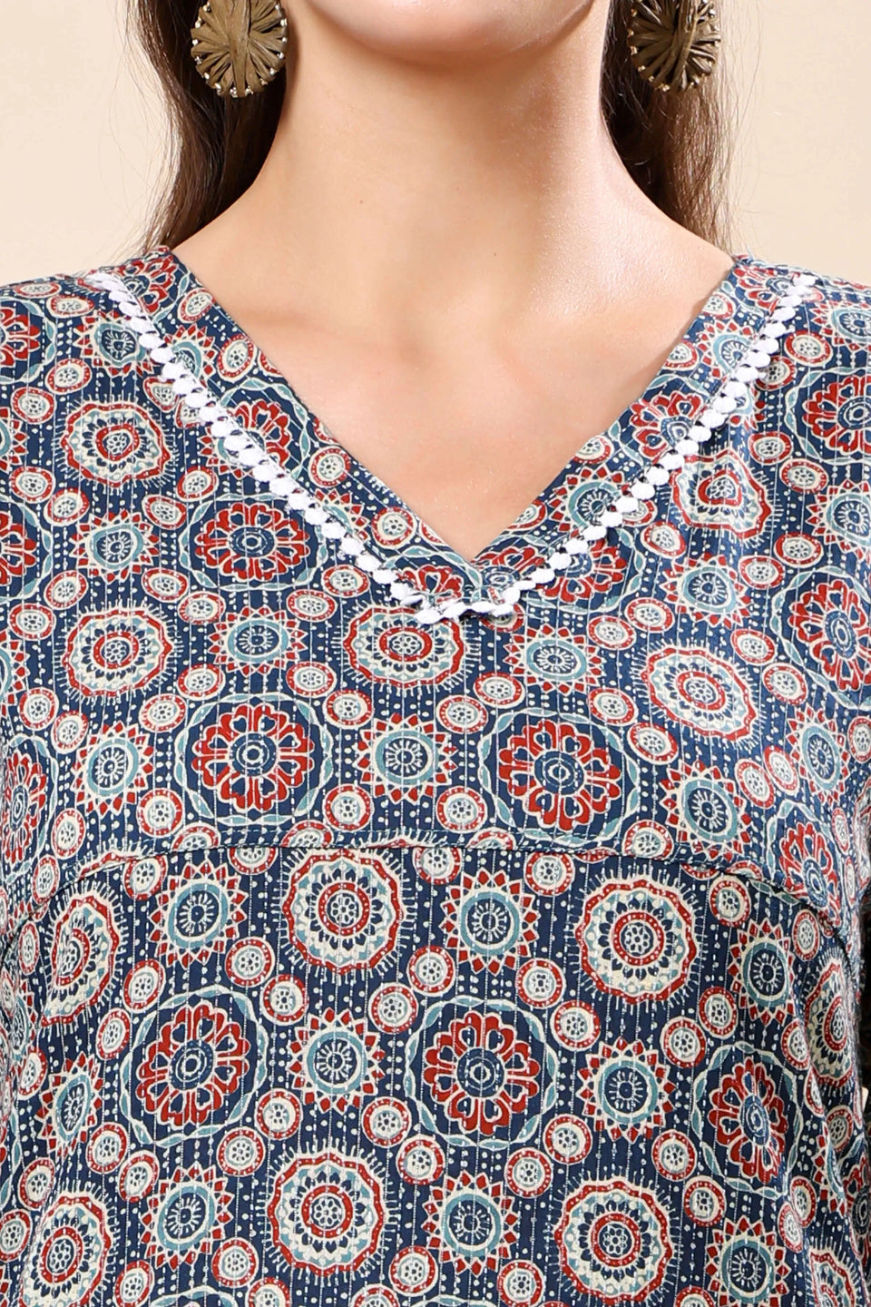 Close-up of geometric mandala print and lace detailing on V-neck kurti