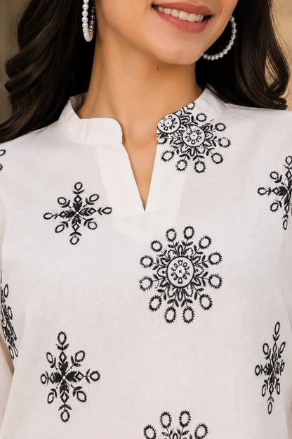 Closeup of Rabric Vertican Silk notch neck kurti design with elegant black floral print detailing on white fabric