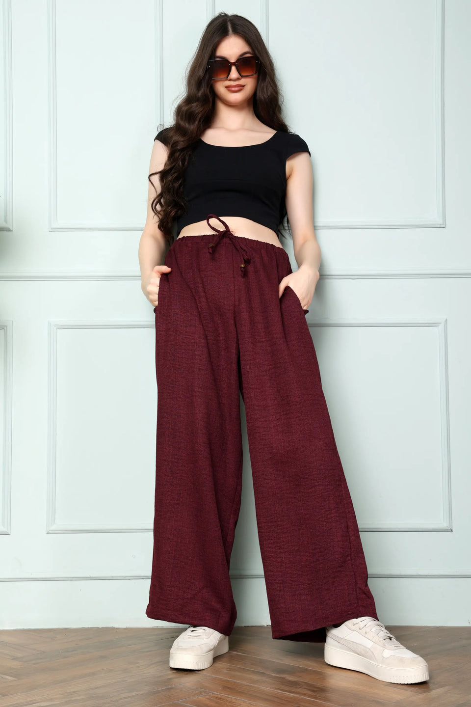Woman wearing RABRIC wine linen wide leg trousers in standing pose showing full-length relaxed fit