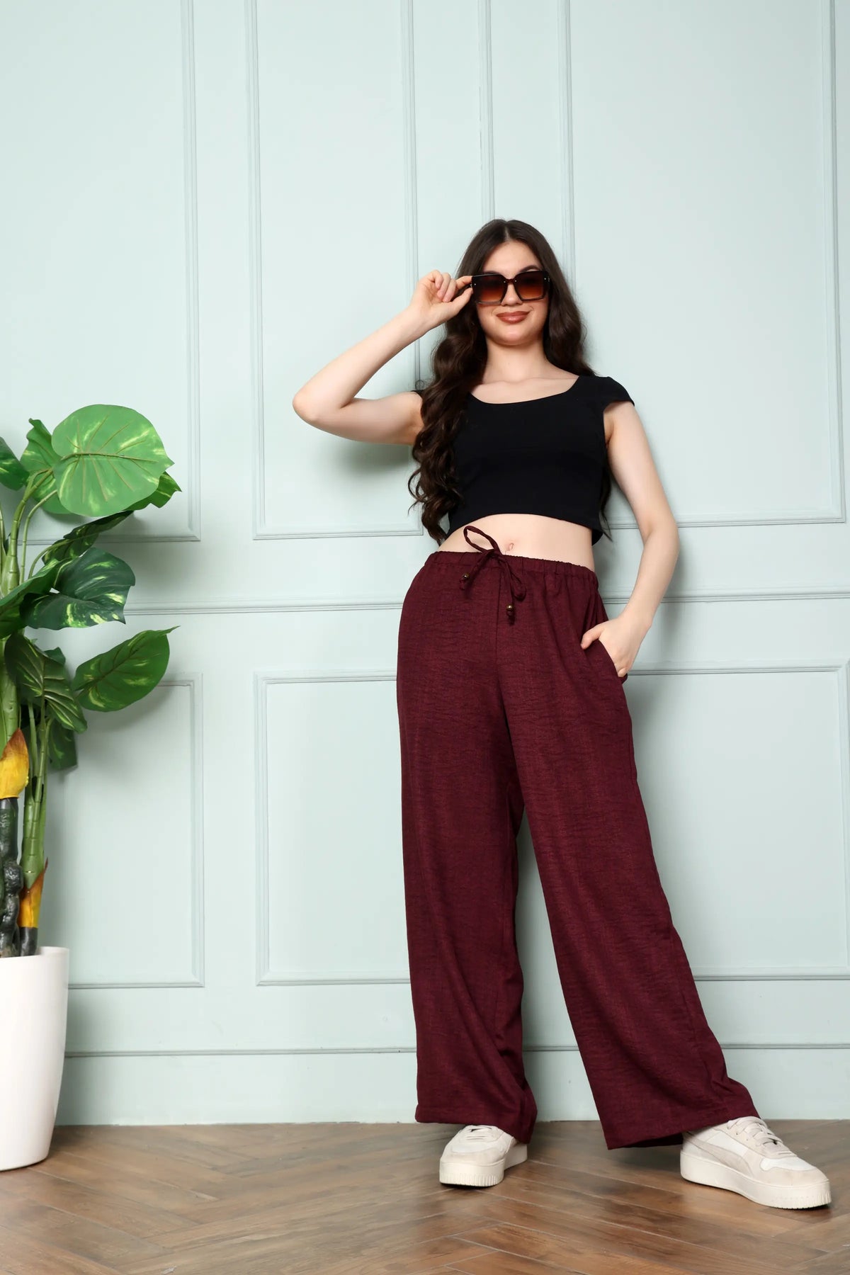 Standing view of RABRIC wine linen drawstring trousers for women with pockets and wide leg design