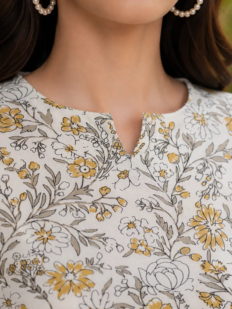 Close up neck design of Rabric off white and mustard yellow floral rayon co-ord set for women with elegant notch neckline detail