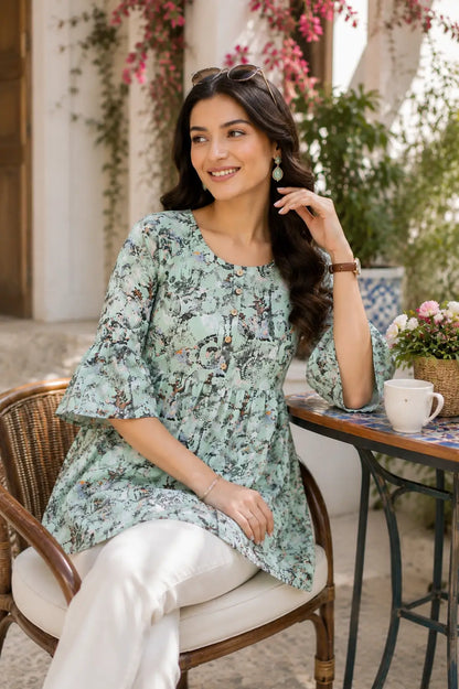 Rabric women cotton short kurti in mint green print styled in casual sitting pose with modern accessories