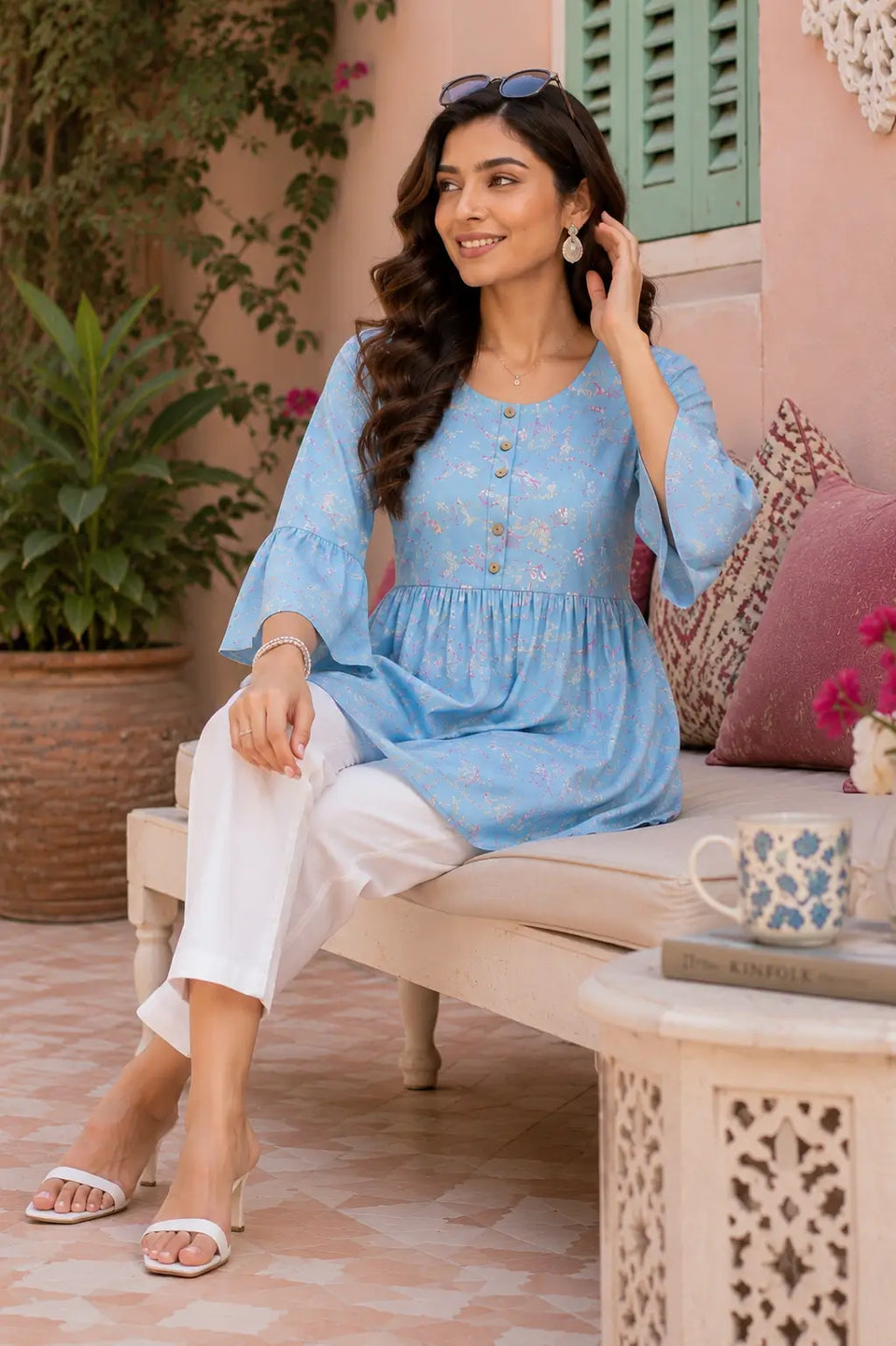 Elegant women sitting pose wearing blue floral cotton short top with stylish accessories