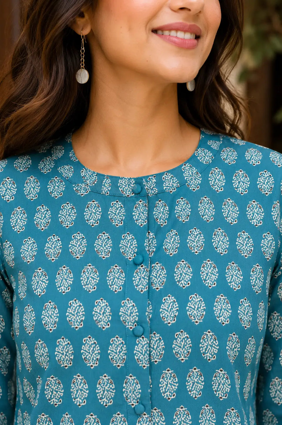 Close up of round neck and front button detailing on Rabric yellow cotton printed women short top