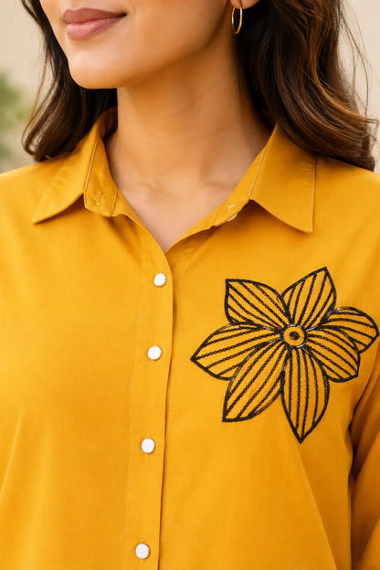 Close-up neck design of Rabric mustard yellow rayon co-ord set with collared neckline, white buttons and black floral embroidery detail for women