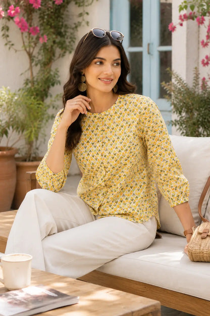 Women casual sitting pose wearing yellow cotton geometric print short top with modern accessories by Rabric