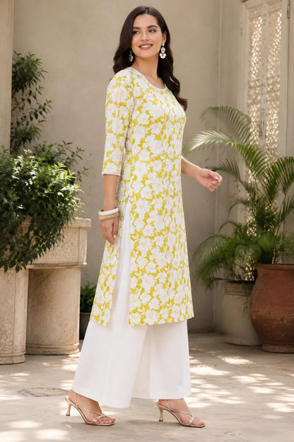 Side angle view of Rabric yellow floral cotton kurti for women with side slit and stylish white palazzo pants